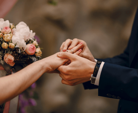 groom putting ring on bride