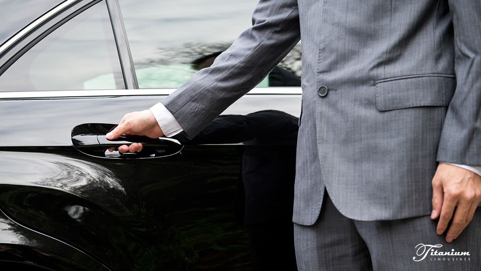 Man in a suit holding car door handle